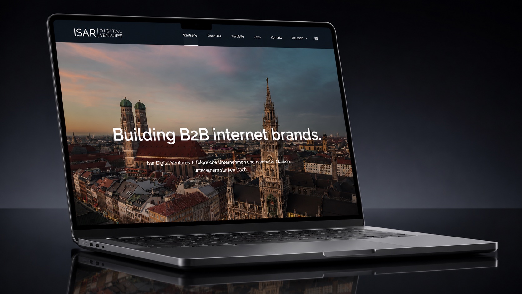 Isar-Digital-Ventures-Website auf einem Laptop vor dunklem Grund: „Building B2B internet brands.“ ueber einer Abendaufnahme der Muenchner Altstadt